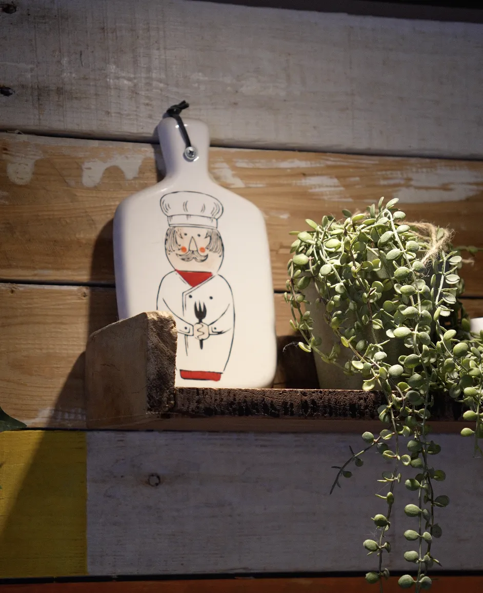 Lille kokkefigur og plante i restauranten